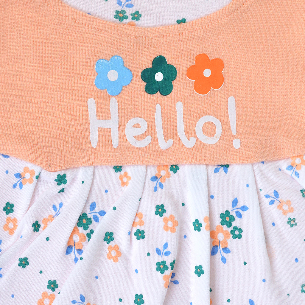 Children's dress with floral pattern and 'Hello!' text on a peach background