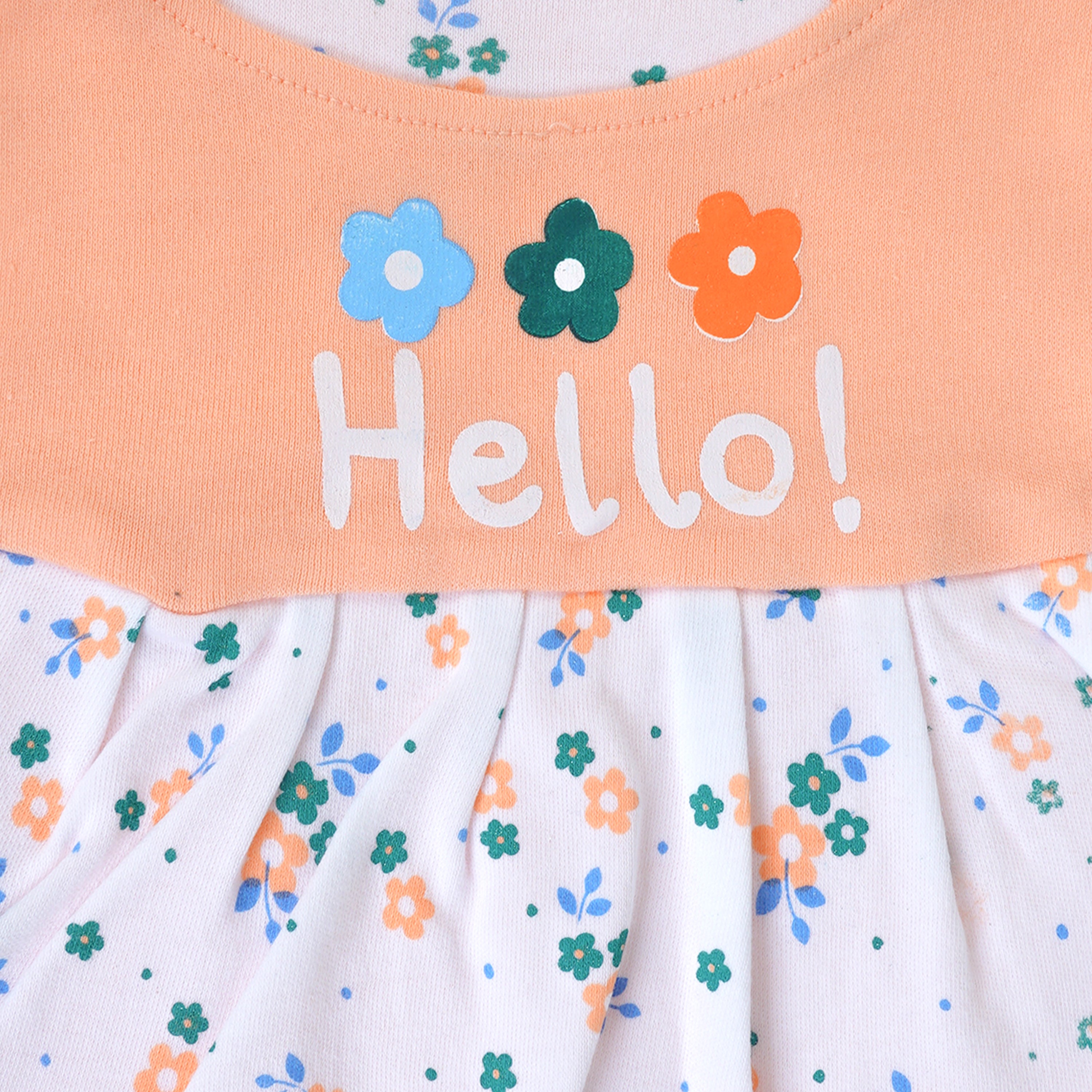 Children's dress with floral pattern and 'Hello!' text on a peach background