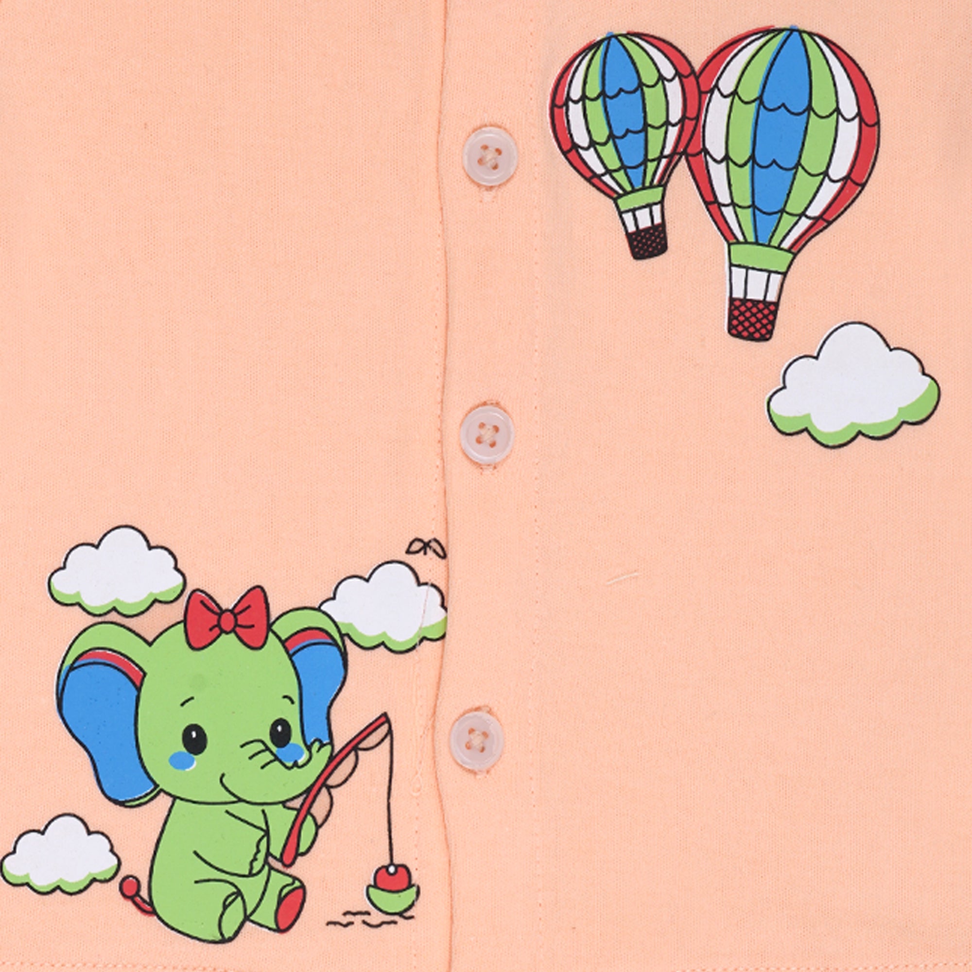 Children's clothing with a green elephant and hot air balloons design on a peach background.